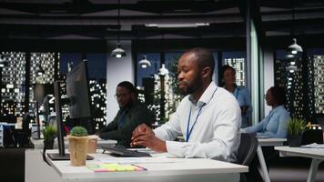 Black office staff building new development strategy with notes, analyzing data and solutions to forecast project outcomes. Professional working overtime on briefing reports. Camera A. video