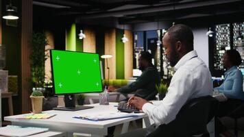 Mockup chroma key on desktop pc with black analyst analyzing KPI metrics, applying a strategic mindset to business development plans. Support innovation and goals achievement. Camera A. video