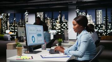 Female professional researching and documenting information after hours, reports updates for the business enterprise in a dark office. Finance targets and project development on pc. Camera A. video