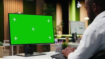 Mockup chroma key on desktop pc with black analyst analyzing KPI metrics, applying a strategic mindset to business development plans. Support innovation and goals achievement. Camera B. video