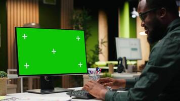 grön skärm på skrivbordet övervaka Nästa till kvinna anställd granskning prognoser, byggnad en ny utveckling strategi till bygga ut företag och lyft prestanda metrik. professionell mål. kamera b. video
