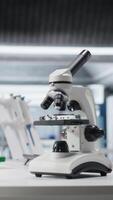 vertikal mikroskop verktyg placerad på skrivbord i laboratorium för vetenskaplig experimentera, instrument Begagnade för genetik forskning och biovetenskap inom professionell anläggningen. bio prov i labb. video