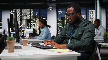 svart medarbetare team övervakning prognos data för en ny en gång i månaden analys i mörk kontor, använda rapporter och insikter till planen rapporter och uttalanden. mål miljö efter timmar. kamera a. video