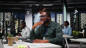 africano americano analista chiedendosi di possibile soluzioni per un' dilemma su computer, concentrazione per valutare proiezioni con logico deduzione e intuitivo osservazione a notte. telecamera un. video