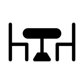 A simple filled icon of a matching table set with chairs. vector