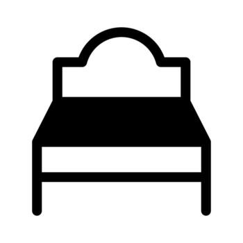 A simple filled icon of a single or small bed frame with pillows. vector
