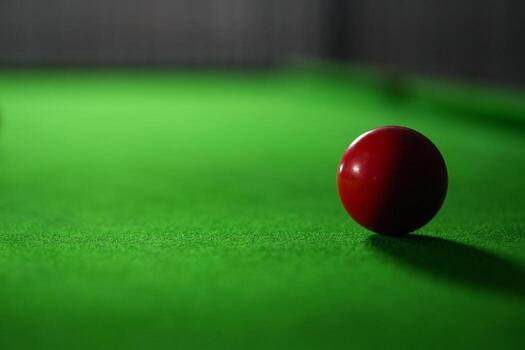 Minimalist image with single red ball, conveying simplicity and focus in a snooker match photo