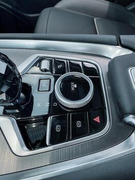 This is a detailed closeup view of a cars dashboard that showcases the intricate design of the steering wheel along with various buttons and controls, highlighting its luxurious features photo