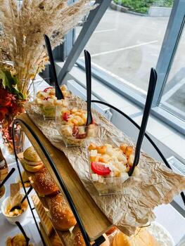 un buffet mesa presentando un formación de delicioso comida artículos desplegado en él, con un encantador ventana que se avecina en el fondo, agregando encanto y ligero a el atractivo ajuste foto