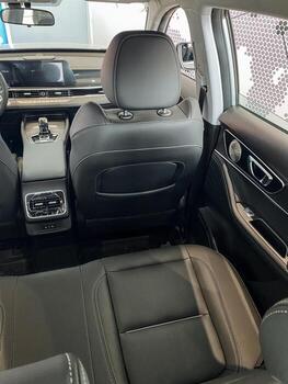 In the back seat of a car, you can find not only a steering wheel but also a rear view mirror, both essential components for safe driving and navigation on the road ahead photo