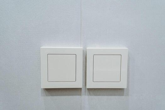 The modern light switches displayed on a gray wall represent a key component of minimalist interior design, emphasizing both functionality and aesthetic appeal within contemporary living spaces photo