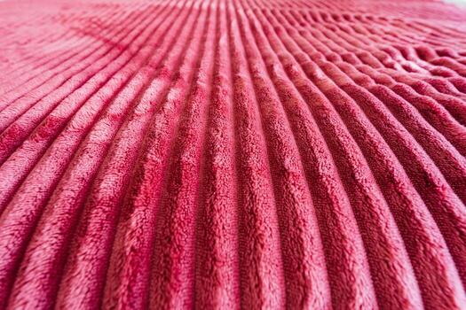 This is a beautifully textured closeup image featuring a soft pink blanket that has intricate wave patterns adorning its surface, creating a serene and cozy visual experience for viewers photo