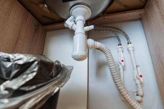 The installation of undersink plumbing involves setting up waste disposal systems and ensuring proper water connections for an efficient drainage system, which is essential for every kitchen remodel photo