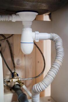 The UnderSink Plumbing System includes a modern PTrap and highquality drainage pipes for efficient sanitation and wastewater management, featuring advanced valves for improved performance photo