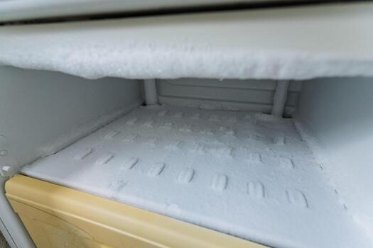 Frost Accumulation Observed in an Empty Freezer Interior Space This phenomenon occurs primarily due to inadequate insulation and temperature variations inside the appliance during winter months photo