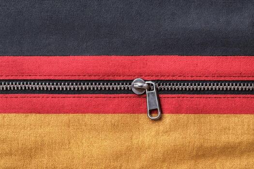Detailed view of a red zipper with metal slider across black and yellow fabric layers, sharp stitching and tidy seam highlight practical fashion design. photo