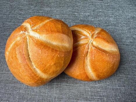 Two golden Kaiser rolls on linen background, top view bakery mockup with copy space photo