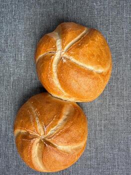Two golden Kaiser rolls on linen background, top view bakery mockup with copy space. photo