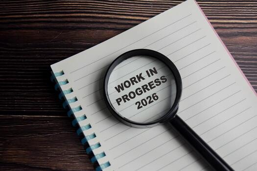 Concept of work in progress 2026 write on book with keywords isolated on Wooden Table. photo