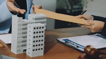 en man är signering en dokumentera med en modell av en byggnad video