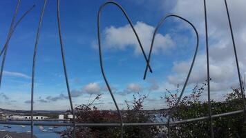 hjärta form trådbunden manuellt i en staket. en se över en stad genom en staket med värme form i Det. video