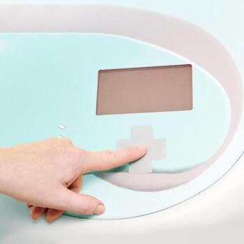 Close-up of hand operating modern medical device with display screen and control button. photo