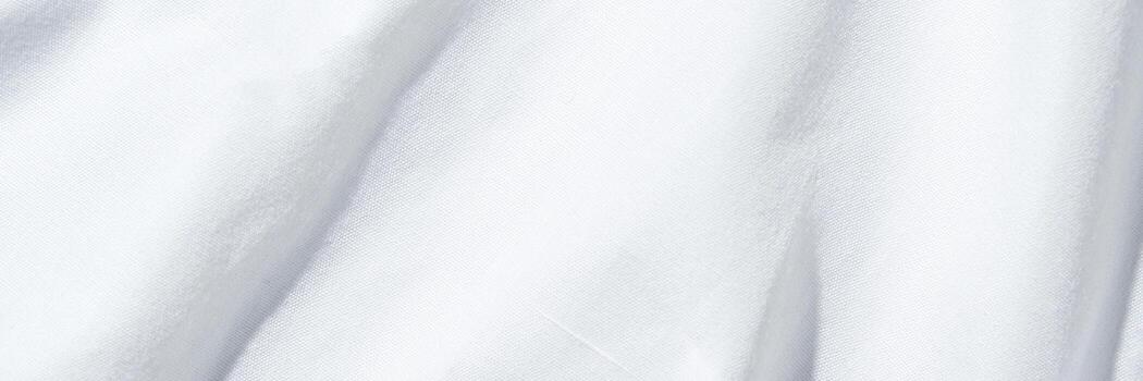 Close-up of smooth white fabric texture with soft light and subtle folds for background. photo