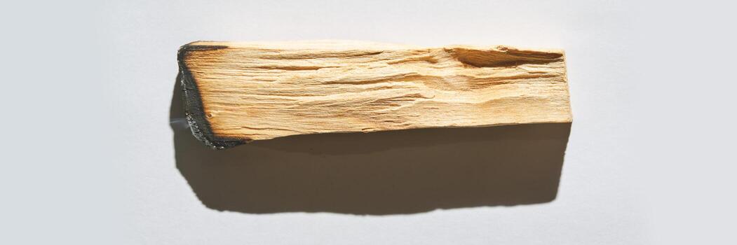 Close-up of weathered wooden plank with distinct grain patterns and shadow on light background. photo