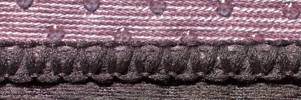 Macro view of textured fabric with intricate purple and dark gray weave patterns and threads. photo