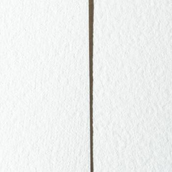 Close-up of textured white paper with vertical fold line in center for background or design element. photo