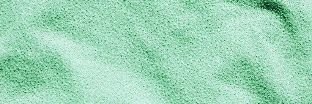 Green textured surface with random speckled pattern and soft fabric appearance. photo