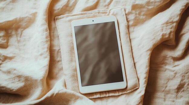 An apple ipad is sitting on top of a bed photo