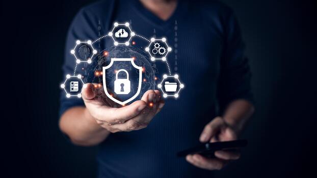 A person holding a glowing shield icon symbolizing cyber security, surrounded by connected digital icons representing data protection, secure networks, and technology safeguards in a dark setting. photo