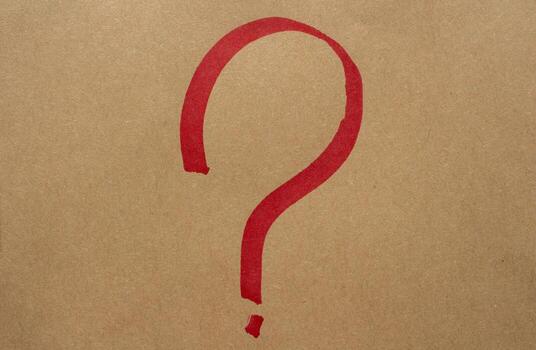 Red hand drawn question mark on brown kraft paper background. Rough marker stroke with textured surface, simple sketch punctuation symbol for notes, retro graphics, and handmade design. photo