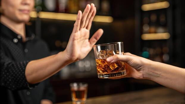 Sober no alcohol party party refusal hand gesture bar bartender refusing drink glass with ice photo