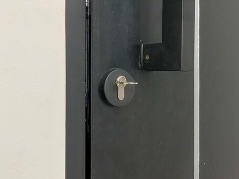 Closeup of a modern dark gray door with a key in the lock symbolizing security and access. photo