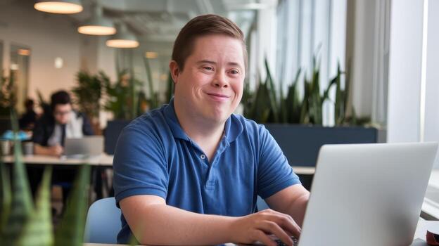 Man With Down Syndrome Smiling and Working on Laptop Computer at His Job in Office photo
