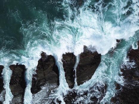 Top View of Turquoise Sea Waves Hitting Sharp Coastal Rocks, Ocean Texture Background photo