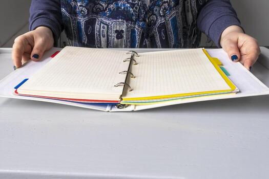 Woman at lectern desk with open binder notebook. Chequered sheets, paper. Copy space for text. photo