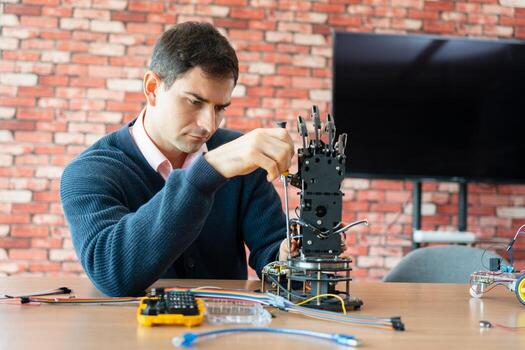 Engineer Assembling a Robotic Arm in a STEM Workshop, Man Fixing or Building a Mechanical Robot, Focused Man Working with Tools and Electronic Components photo
