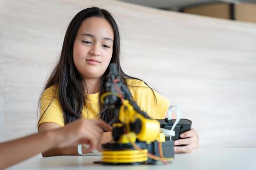 adolescente niña aprendizaje codificación y controlador un robótico brazo, las manos en vástago educación, joven hembra estudiante trabajos en robótica proyecto, inteligente niño comprometido en tecnología y mecánico diseño foto