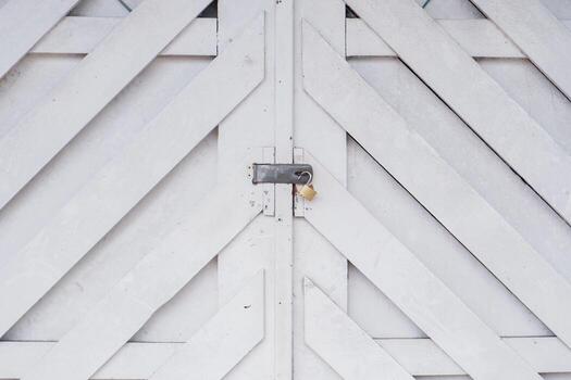 White wooden double door with diagonal plank pattern and metal latch, creating a rustic geometric texture background perfect for architecture or design concepts. photo