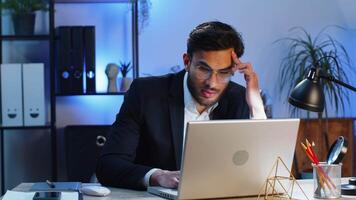 irritata stanco indiano attività commerciale uomo mentre Lavorando su computer portatile, inaspettato in linea sito web problema, computer virus dati perdita di hacking. libero professionista sensazione pazzo di rotto taccuino a ufficio posto di lavoro video