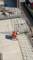 construção trabalhador medindo vergalhão estrutura em construção estrutura. uma construção trabalhador dentro segurança engrenagem medidas aço vergalhão , visto a partir de acima. video
