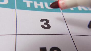 Highlighting date number 3 on a calendar, with a bold red cross mark emphasizing an important reminder or scheduled event. video