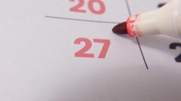 highlighting datum siffra 27 på en kalender, med en djärv röd korsa mark betona ett Viktig påminnelse eller planerad händelse. video