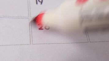 The 26th on the calendar is circled in red marker in a close-up macro shot on a white page, symbolizing an important day or reminder. video