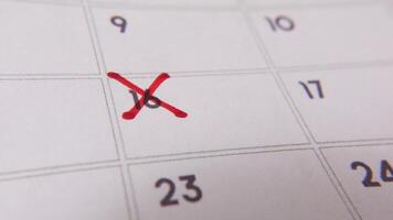 destacando fecha número dieciséis en un calendario, con un negrita rojo cruzar marca enfatizando un importante recordatorio o programado evento. video
