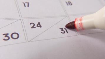 Marking the date number 31, focusing on the number highlighted with a red cross on the calendar. Represents deadlines, reminders, planning, and time management video