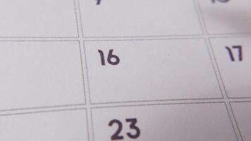 The 16th on the calendar is circled in red marker in a close-up macro shot on a white page, symbolizing an important day or reminder. video